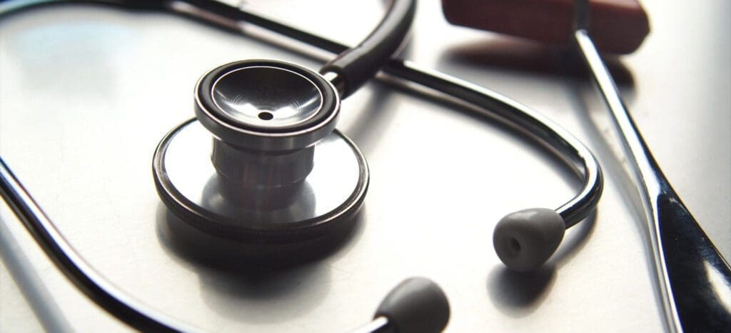 A stethoscope and ear buds on top of a table.